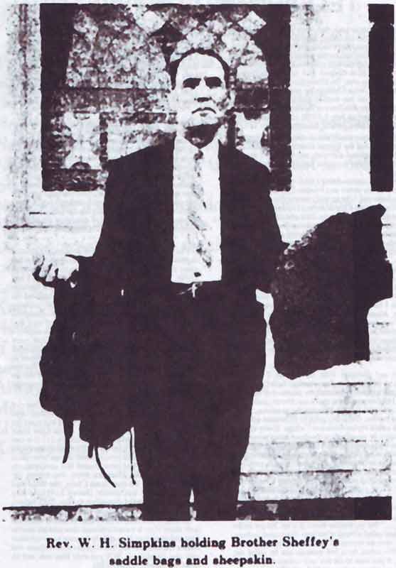 Preacher Simkins holding the circuit rider's saddle bags and lamb skin